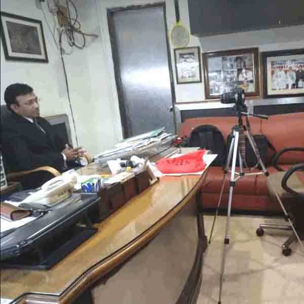 International SEO Freelancer India working in office with tripod and documents